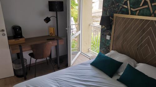 a bedroom with a bed and a desk and a table at Le Relais du Chapeau Rouge in Saint Loup Lamaire