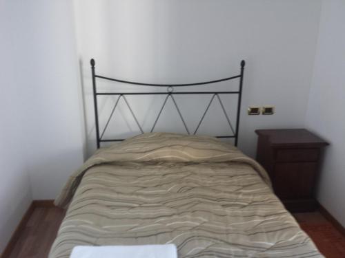 a bed in a room with a black frame at Farmstay Alloggio Cort di Branc in Povoletto