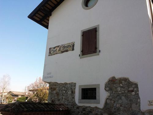 a building with a sign on the side of it at Farmstay Alloggio Cort di Branc in Povoletto
