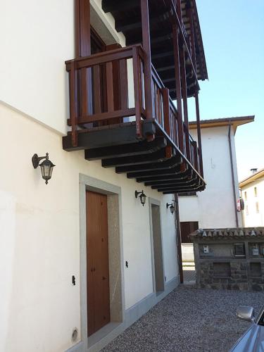 a building with a wooden door and a balcony at Farmstay Alloggio Cort di Branc in Povoletto