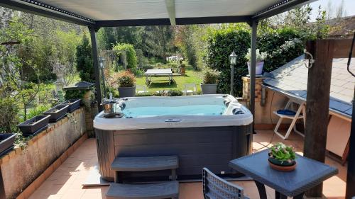 an outdoor hot tub on a patio with an umbrella at Le Pavillon Tilia in Montrichard