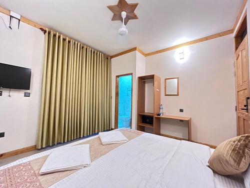 a bedroom with a large white bed and a window at Burulu Inn in Gaafaru