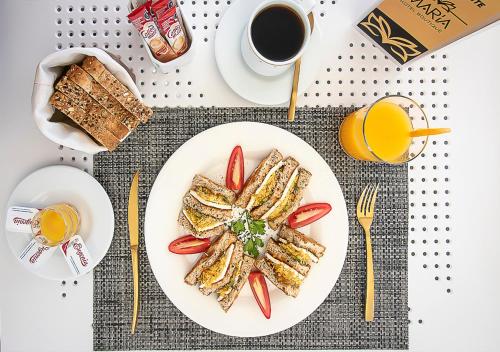 a plate of toast with tomatoes and a cup of coffee at Hotel Boutique Maria in Morelia