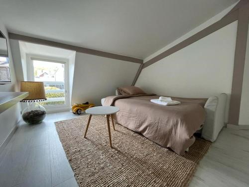 - une chambre avec un lit, une table et un tapis dans l'établissement Maison/ Loft familial à Etretat, à Étretat