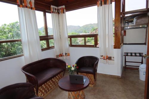 a room with two chairs and a table with a laptop at Ma Petite Maison in Tepoztlán