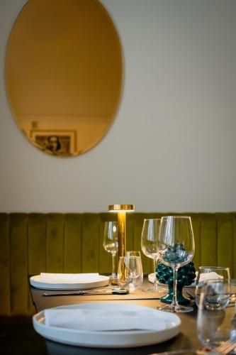 a table with wine glasses and a plate on it at La Dépendance Hotel in Noto