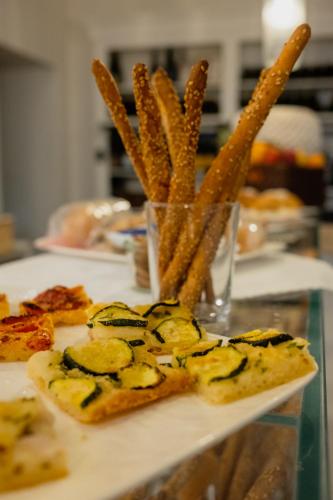 a plate of food with a pizza and french fries at La Dépendance Hotel in Noto