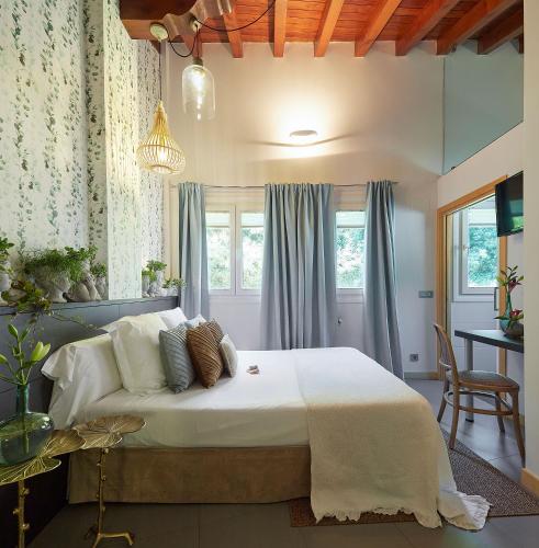 a bedroom with a large bed with white sheets and pillows at Hotel Boutique Txanka Erreka PARKING INCLUIDO in Orio