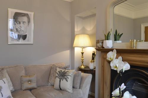 a living room with a couch and a mirror at Stunning Period Townhouse with Garden, Walking Distance to Town in Dumfries