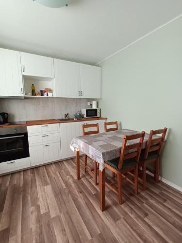 a kitchen with white cabinets and a table and chairs at Place to stay in Drøbak in Drøbak