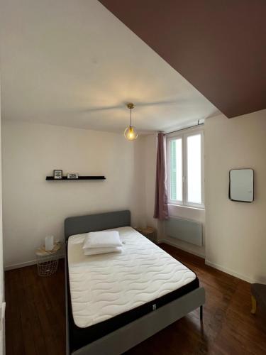 une chambre avec un lit et une fenêtre dans l'établissement Escapade dans grand T2 de charme avec terrasse - Proche Gare et Centre ville, à Lourdes