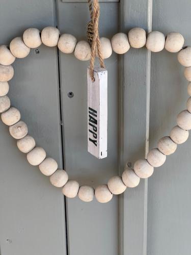 a wooden heart wreath on a door with a tag at Mas Coeur Provence Calme Beauté Grand Parc in Pernes-les-Fontaines