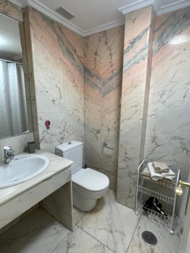 y baño con aseo y lavamanos. en Loft Edificio Maura Primera Playa, en Santander