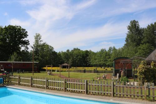 een hek rond een zwembad met een park op de achtergrond bij Pia B&B Babbita in Hasselt