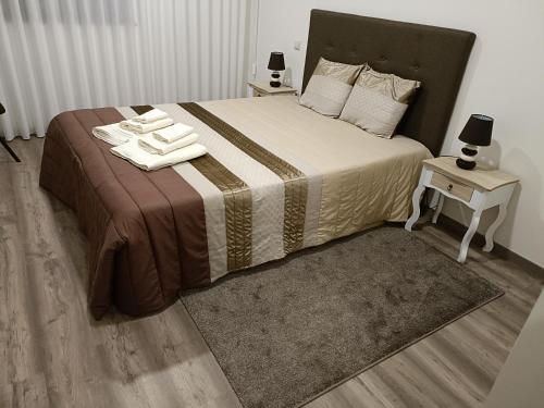 una camera da letto con un letto e due asciugamani di Olhares do Lobo - Restaurante Lobo a Ponte da Barca