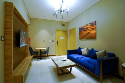 a living room with a blue couch and a table at Al Aseel Hotel in Doha