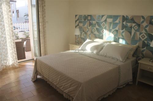 um quarto com uma cama com uma cabeceira azul e cinzenta em Dimora Mariò em Marina di Mancaversa