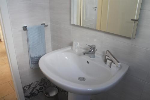 um lavatório branco na casa de banho com um espelho em Dimora Mariò em Marina di Mancaversa