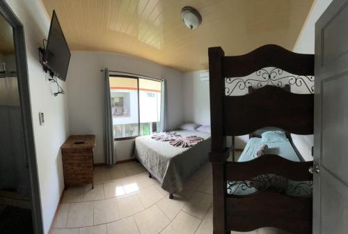 a bedroom with a bunk bed and a window at Hotel Cabinas el Tecal in Uvita