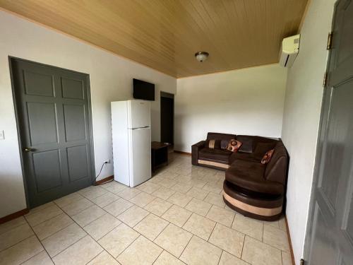 a living room with a couch and a refrigerator at Hotel Cabinas el Tecal in Uvita