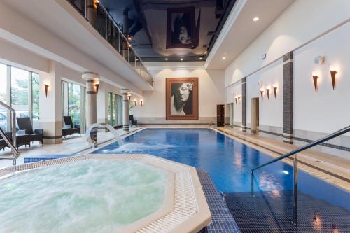een groot zwembad met een hot tub in een gebouw bij Hotel Lambert Medical Spa in Ustronie Morskie