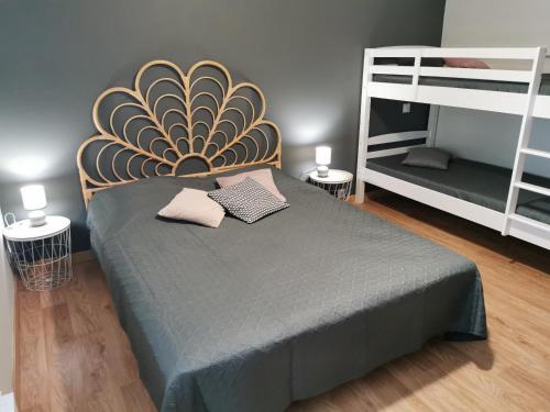 een slaapkamer met een bed en 2 stapelbedden bij La Salicorne in Brem-Sur-Mer