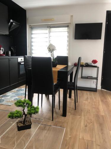 une salle à manger avec une table et des chaises noires dans l'établissement Charmante maison de ville, à Périgueux