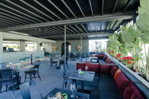 a restaurant with a couch and tables and chairs at JM Suites Hotel Eco-Friendly Casablanca in Casablanca