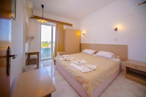a bedroom with a bed with towels on it at Sea Harmony in Kalathos