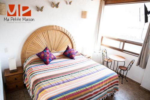 a bedroom with a large bed and a window at Ma Petite Maison in Tepoztlán