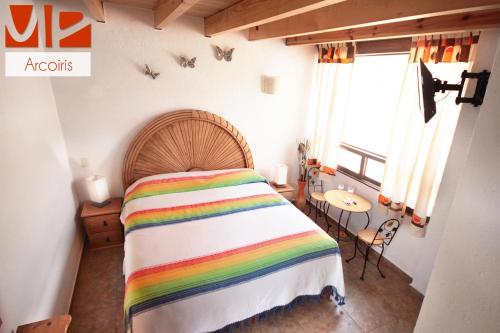 a bedroom with a rainbow bed and a table at Ma Petite Maison in Tepoztlán