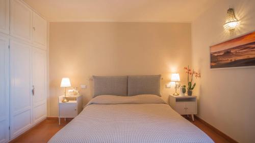 1 dormitorio con 1 cama grande y 2 mesitas de noche en Suite Le Palme con terrazze in centro, en San Gimignano