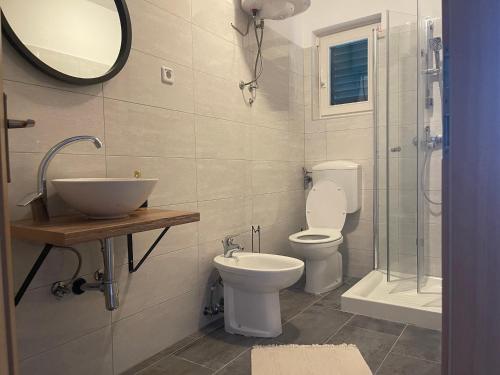 ein Bad mit einem WC, einem Waschbecken und einer Dusche in der Unterkunft Villa Nika in Valun