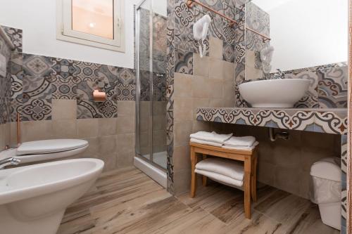 a bathroom with a sink and a toilet and a shower at Sisula Country Hotel & SPA in Orosei