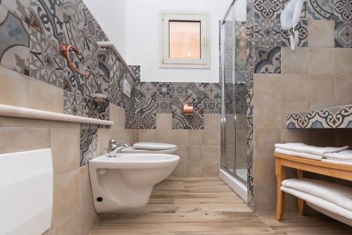 a bathroom with a toilet and a sink and a shower at Sisula Country Hotel & SPA in Orosei