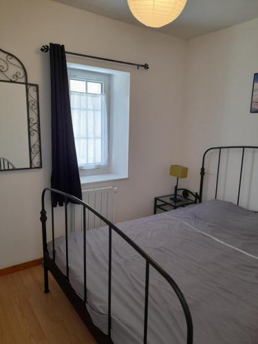 une chambre avec un lit et une fenêtre dans l'établissement Promo F2 wifi Courseulles sur mer, à Courseulles-sur-Mer