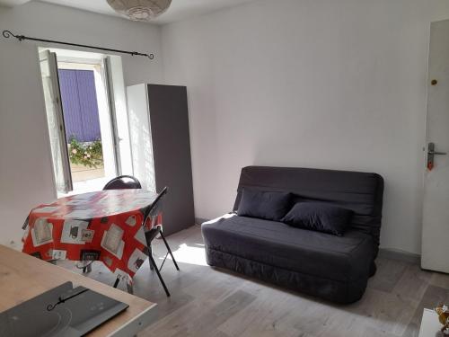 un salon avec un canapé et une table dans l'établissement Promo F2 wifi Courseulles sur mer, à Courseulles-sur-Mer