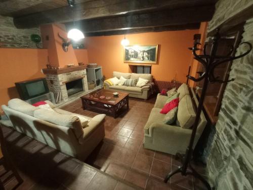 sala de estar con 2 sofás y chimenea en Casa de Abril 2, en San Cristóbal de Valdueza