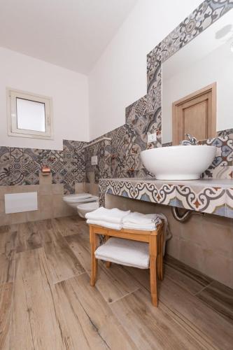 a bathroom with two sinks and two toilets at Sisula Country Hotel & SPA in Orosei