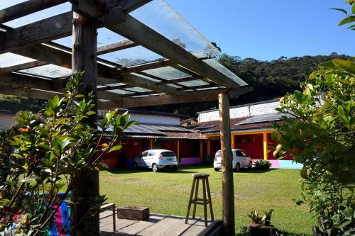 a wooden pergola in a yard with a building at Caminito in Santo Antônio do Pinhal
