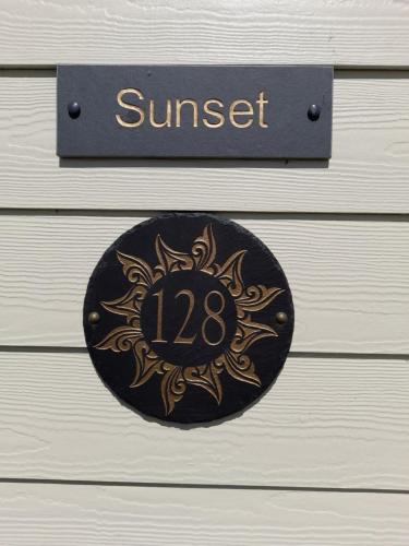 a black and gold sign on a wooden door at Sunset 128 Sandown Bay Holiday Centre Generous Ferry Saving! in Sandown