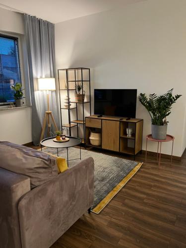 a living room with a couch and a flat screen tv at Przytulny Apartament Mickiewicza 14/1 in Wieleń