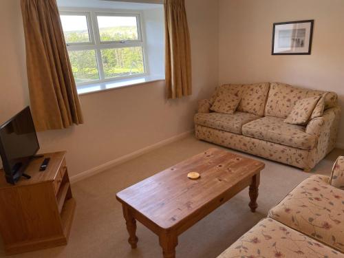 a living room with a couch and a coffee table at Church House Farm in Danby