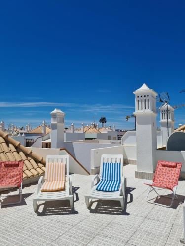 a group of chairs sitting on top of a roof at Apartamento Duplex em Cabanas de Tavira in Tavira