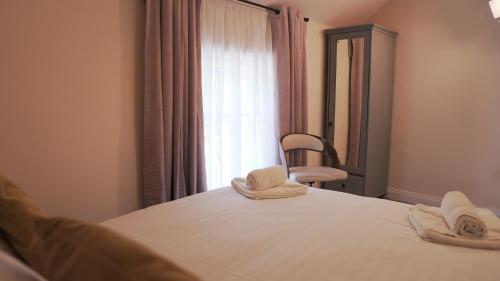 a bedroom with a bed with a mirror and a chair at Meadow Terrace in Shrewsbury