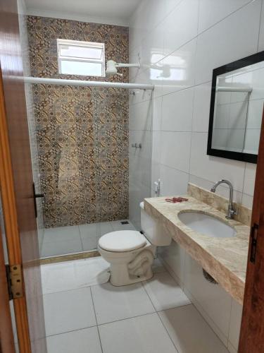 a bathroom with a toilet and a sink at Pousada Coqueiral in Aracruz