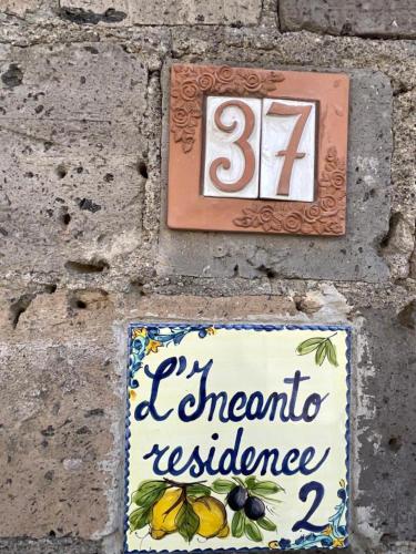a sign on a brick wall with a sign for a restaurant at Residence l'Incanto in Piano di Sorrento
