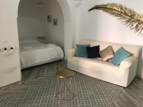 a living room with a couch and a bed at L’alcova del centro in Pantelleria