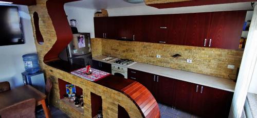 a kitchen with red cabinets and a counter top at Casa de vacanță Dalia și Crina in Babadau