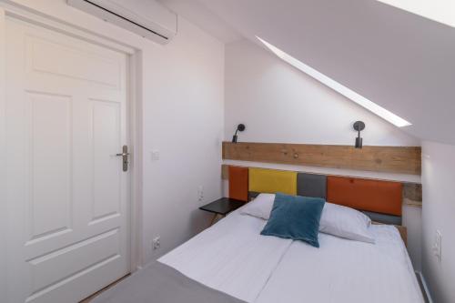a bedroom with a white bed with a wooden headboard at Przy Poznańskiej Bramie in Inowrocław